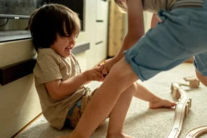 sibling rivalry is hard. This little boy is crying because his big brother is taking away his toy train