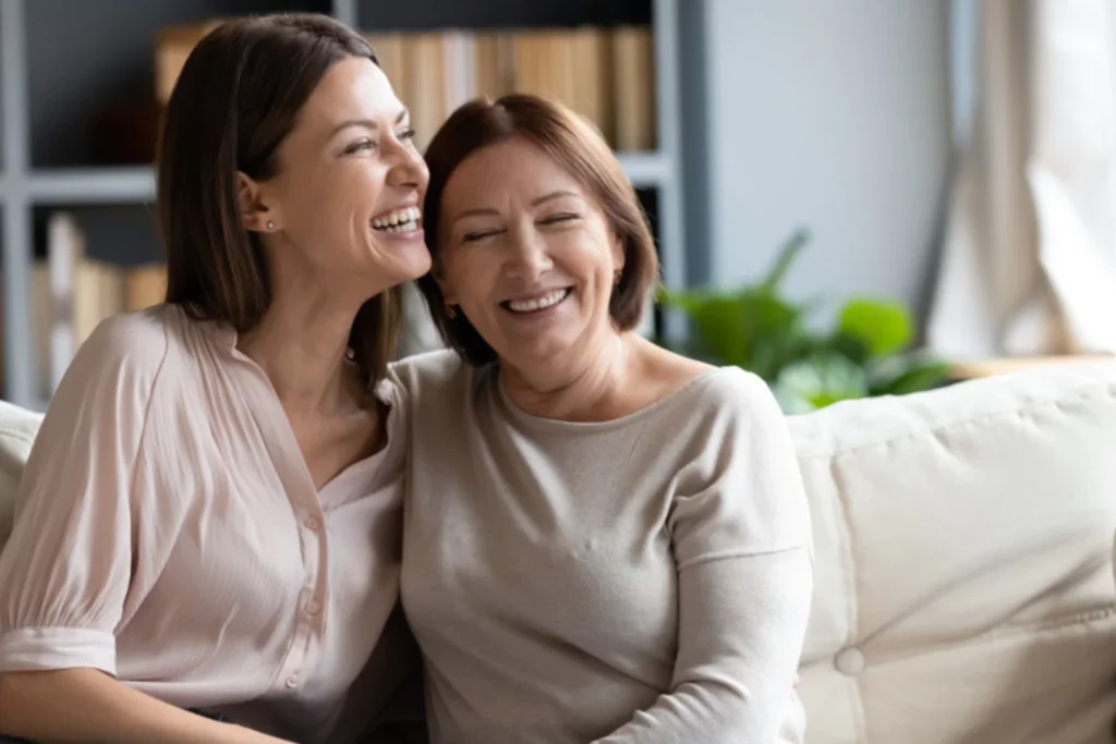 parenting adult children. Mother and adult daughter smiling with a warm embrace