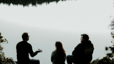 Couple sitting by like with man