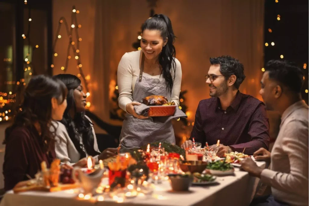 taking the stress out of family gatherings, a table full of foods, with a family gathered around smiling.