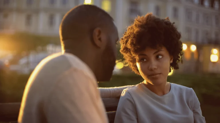 A couple sitting on a bench at dusk, engaged in a thoughtful conversation, illustrating the need for shifting your perspective on marriage and fostering deeper emotional understanding.