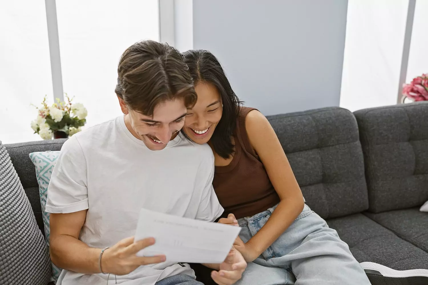 A husband and a wife sit closely together on a couch, reading over some discussion questions on a piece of paper. This marriage mentoring discussion guide explores 10 characteristics essential ingredients in creating lasting, thriving unions.