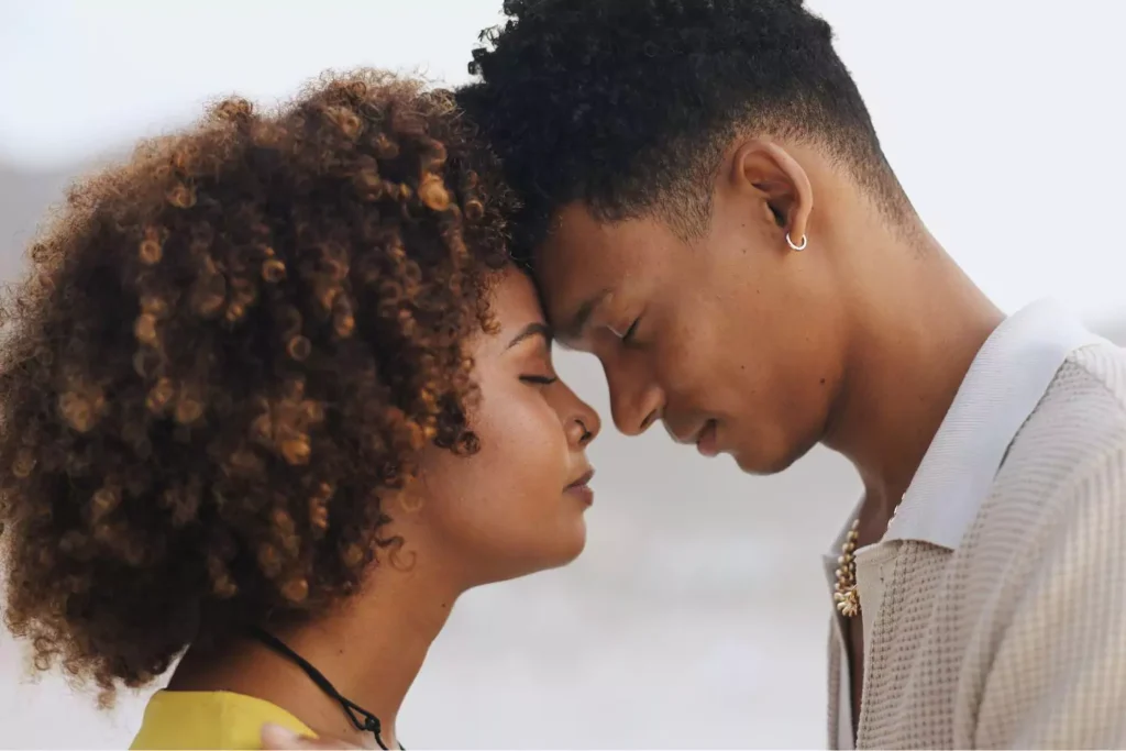 A close-up of a couple gently pressing their foreheads together, eyes closed, symbolizing unity in marriage and deep emotional and spiritual connection.