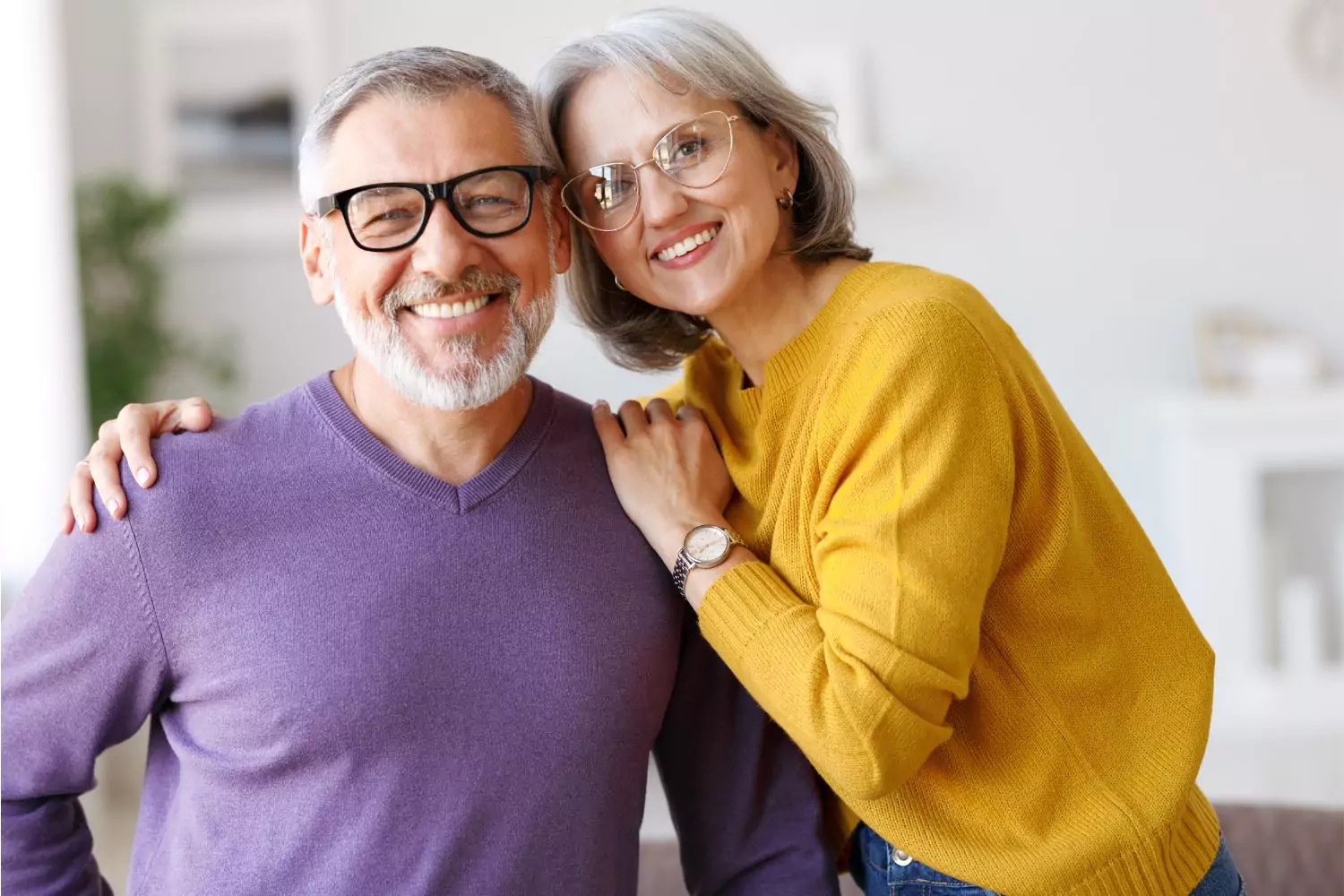 A happy, mature couple smiling and embracing each other, demonstrating the strength and harmony that can come from dealing with differences in marriage.