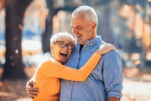 A joyful elderly couple embraces, reflecting a strong heart connection in their marriage.