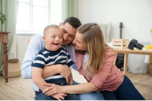 A joyful family embracing their child with Down syndrome, symbolizing the love and support involved in special needs care.