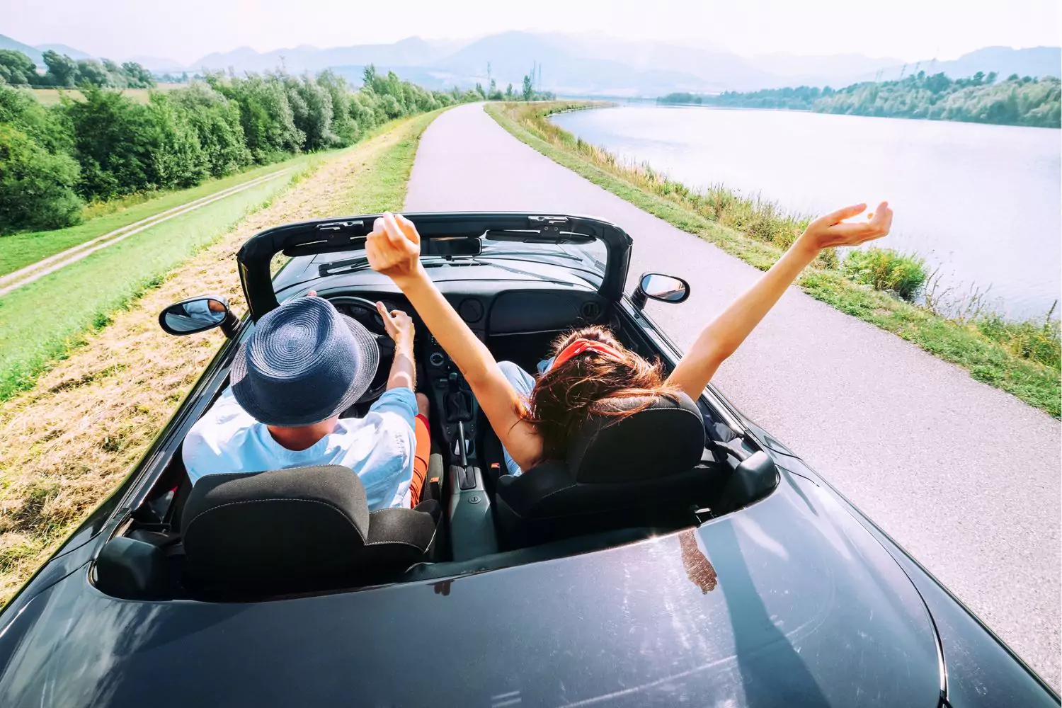 A couple drives down a scenic road in a convertible, symbolizing the journey of course correction in marriage, enjoying the open road and embracing new directions together.