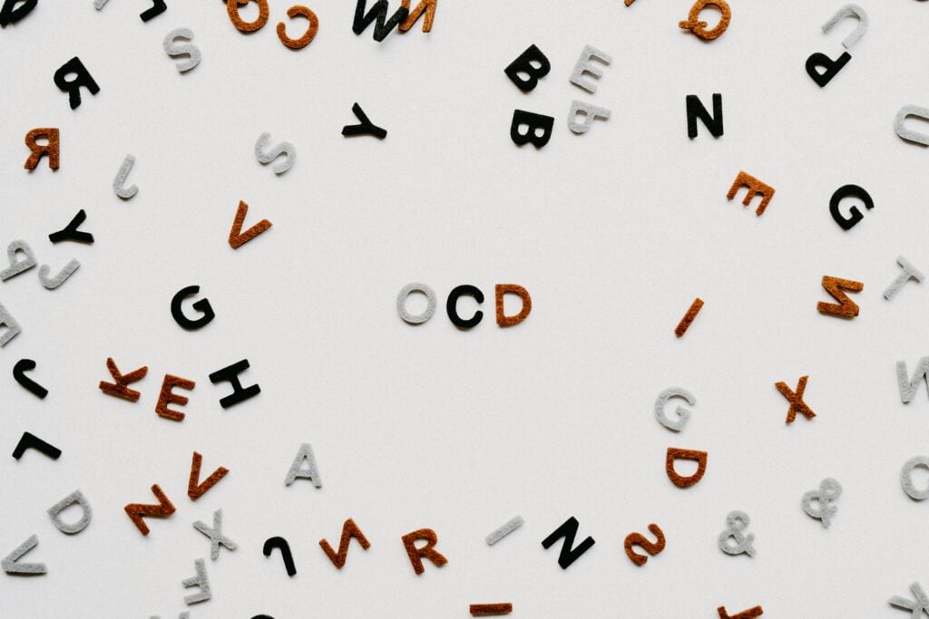 a jumble of tile letters are scattered around, but OCD is clearly spelled out in the middle