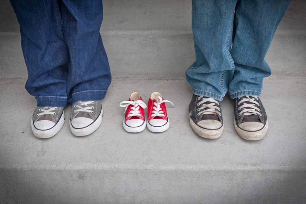 Parents with pair of empty shoes between them