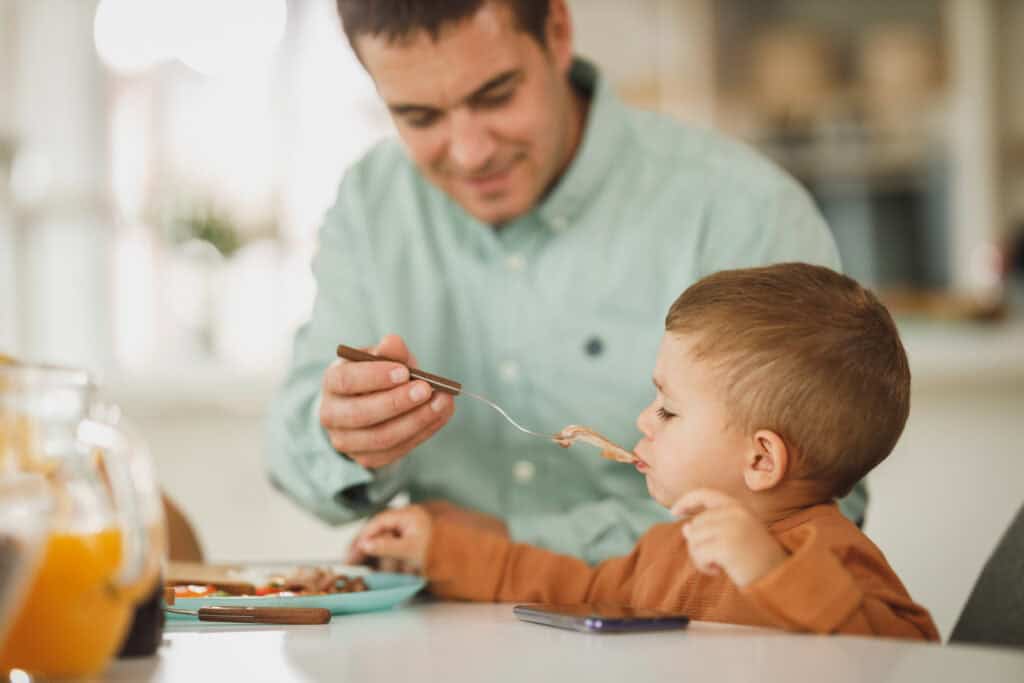 dad feeding toddler