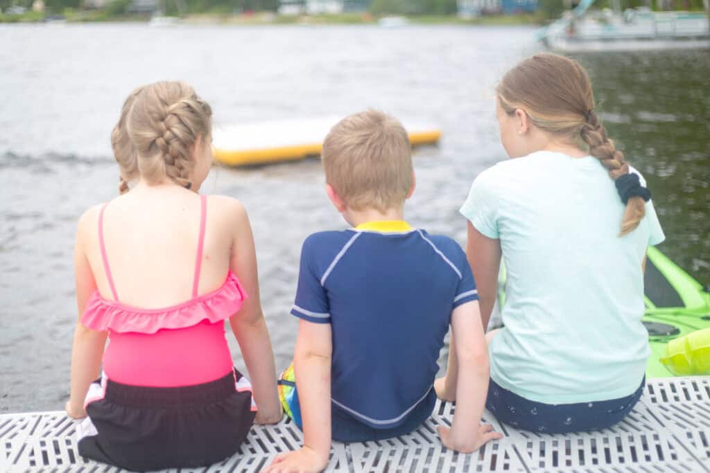 two girls and a boy backs to camera looking at water