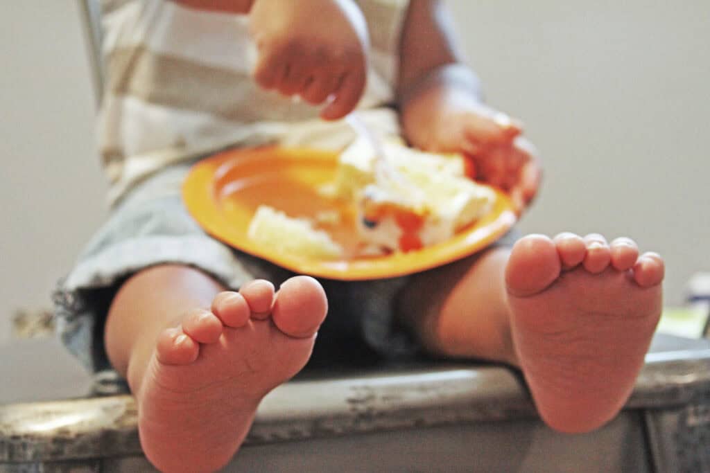 toddler holding plate of food