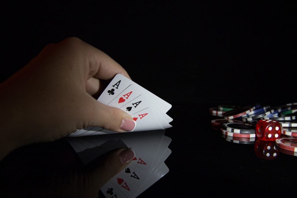 Hand holding cards near poker chips