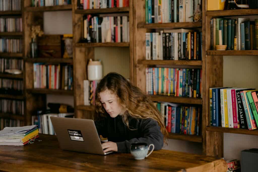 teen girl sitting in front of laptop