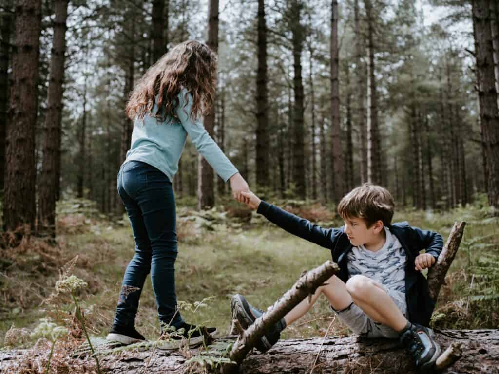 girl helping boy up