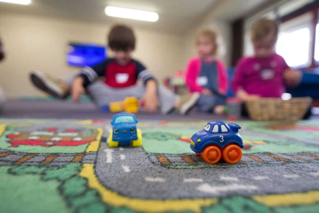 toy cars with children in the background