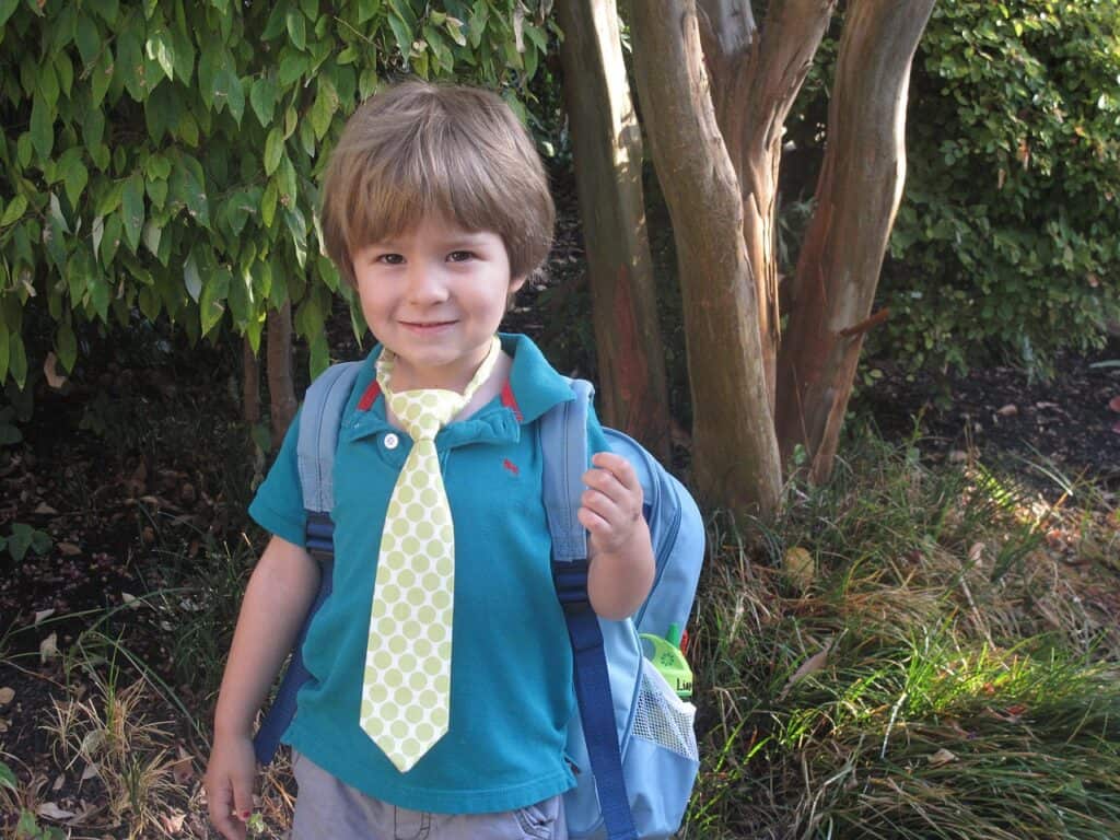 preschool boy with necktie and backpack