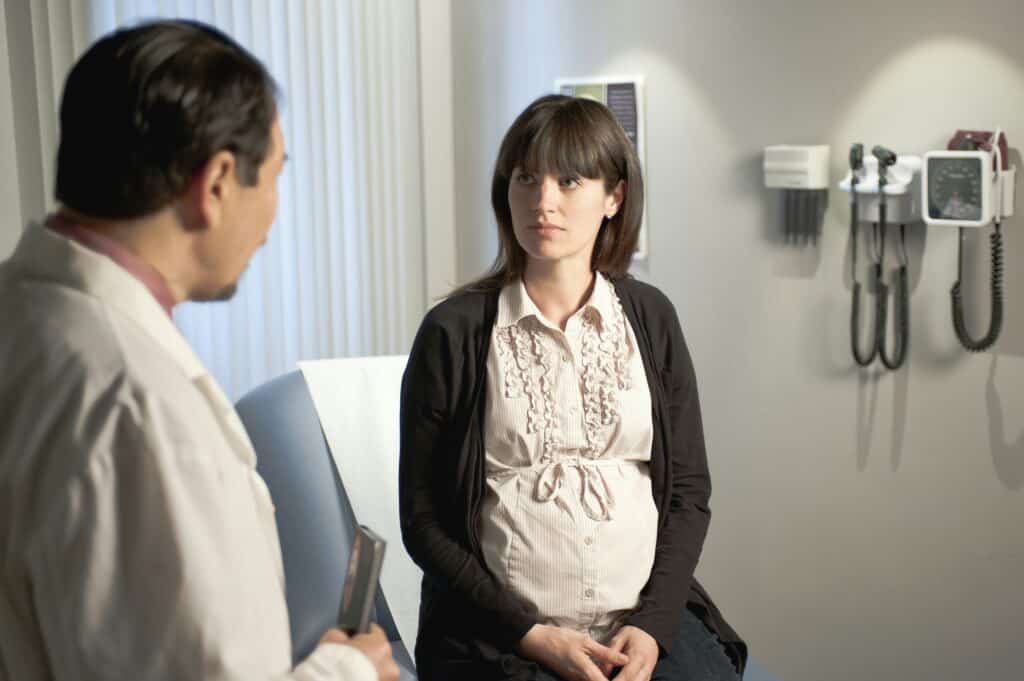 Pregnant woman listening to doctor