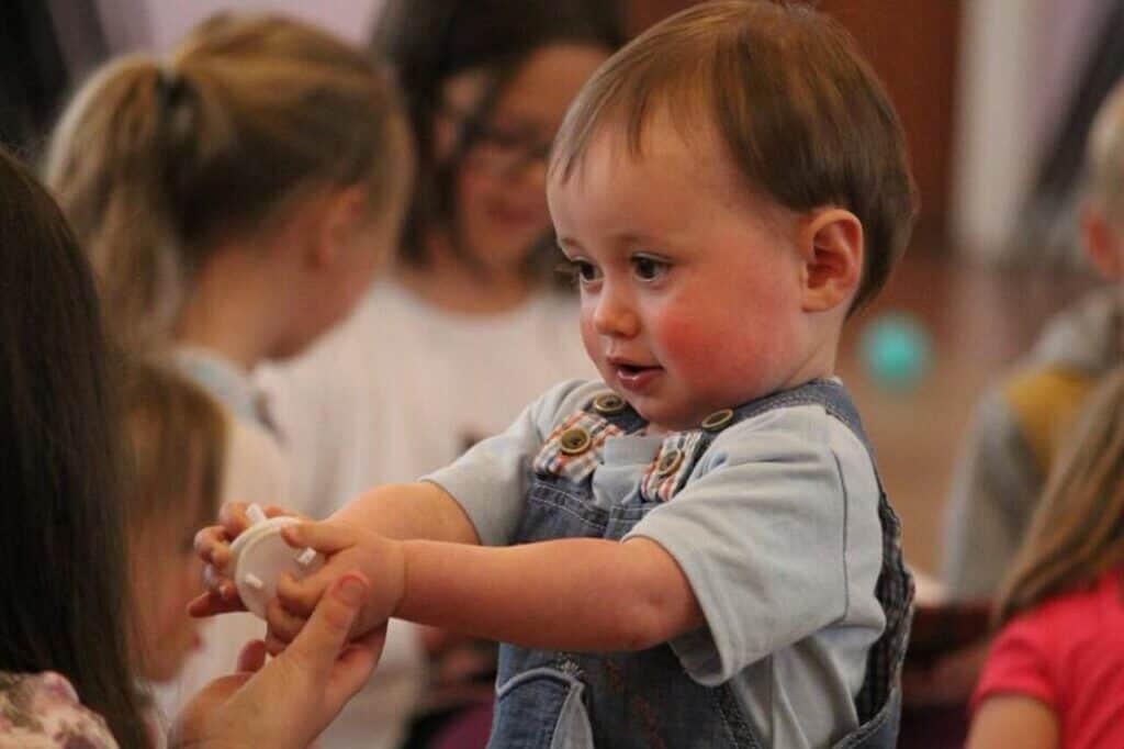 child playing with other kids in background