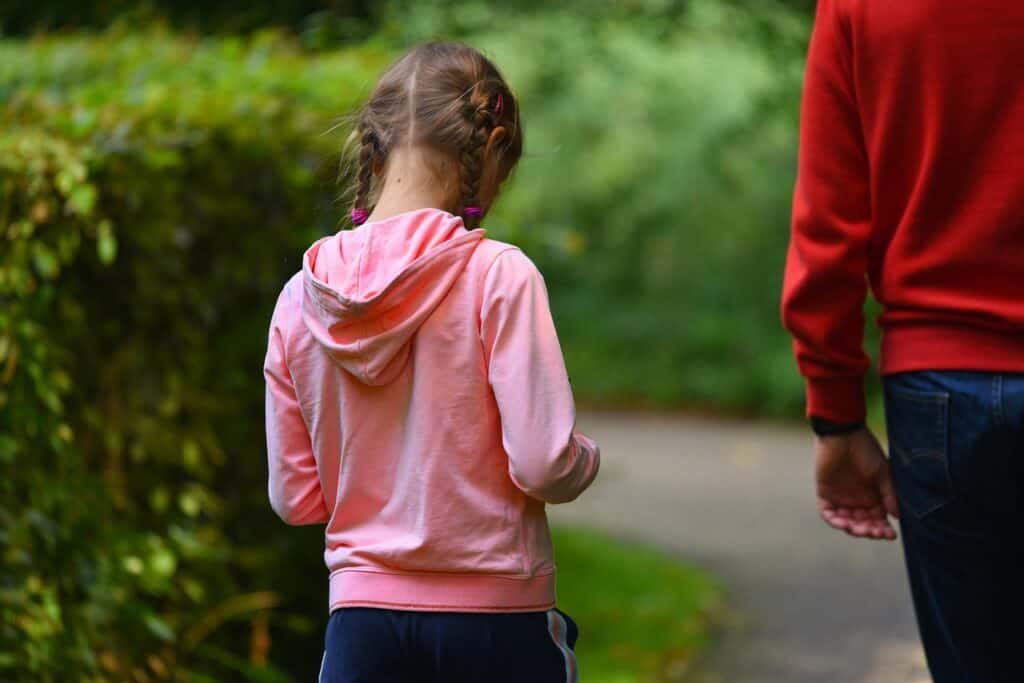 girl walking behind dad