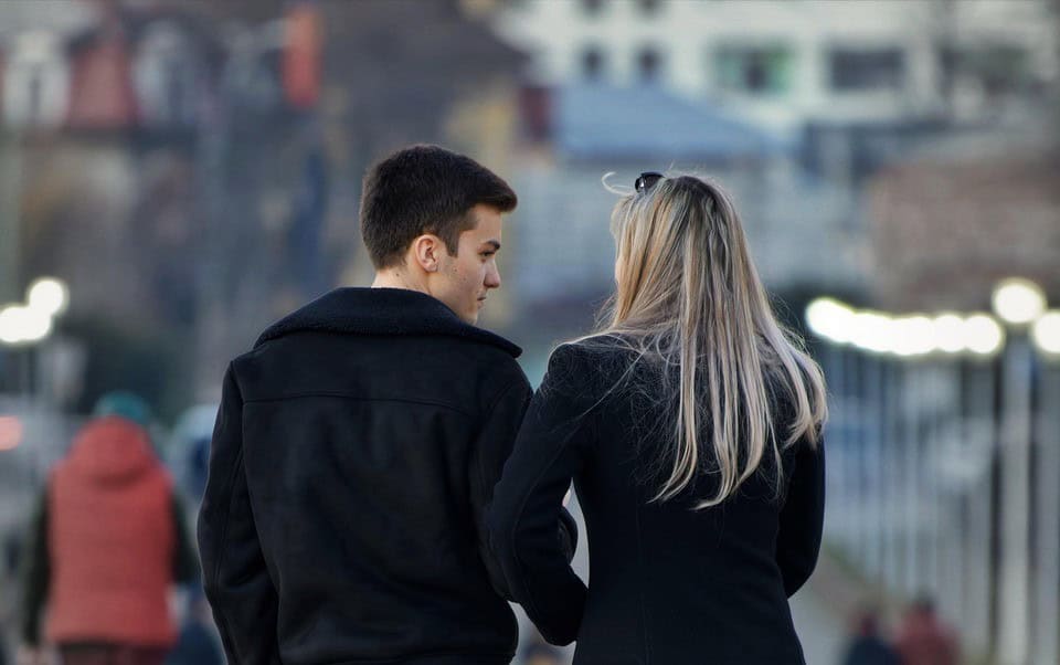 back of couple walking down street