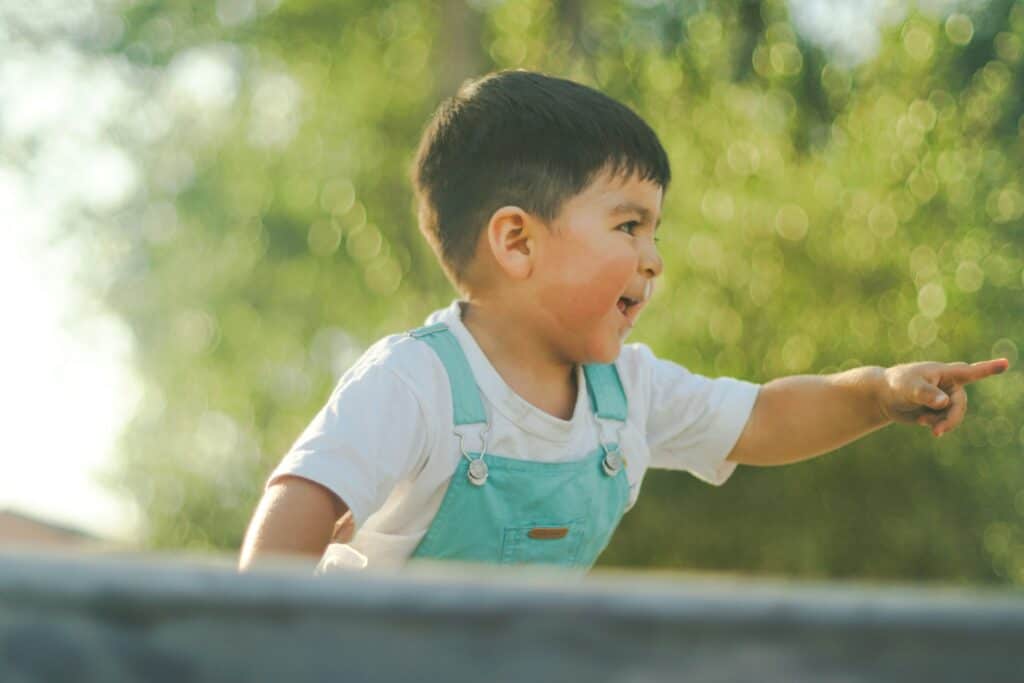 small child pointing at someone