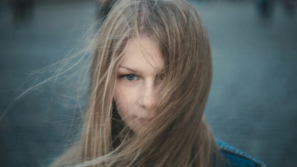 moody teen girl hair covering face