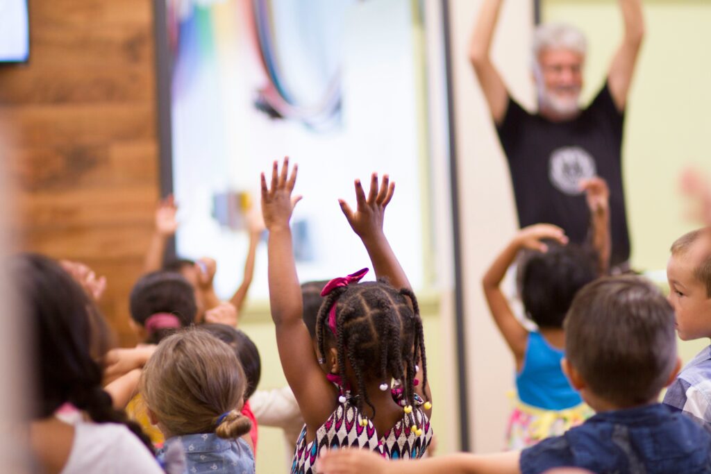 kids raising their hands in worship at chruch