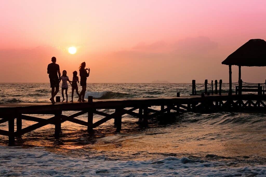 family on pier at sunset