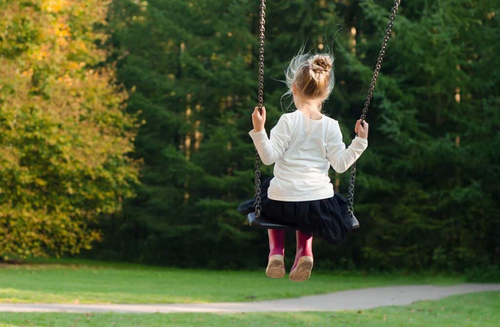 girl back to camera swinging outside
