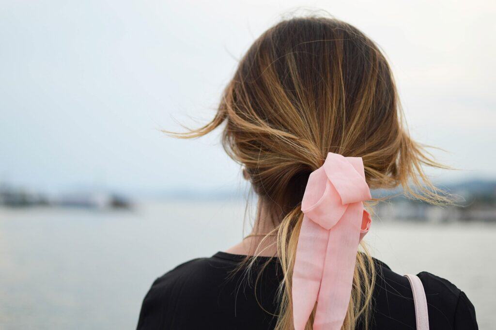 back of young woman's head pink bow