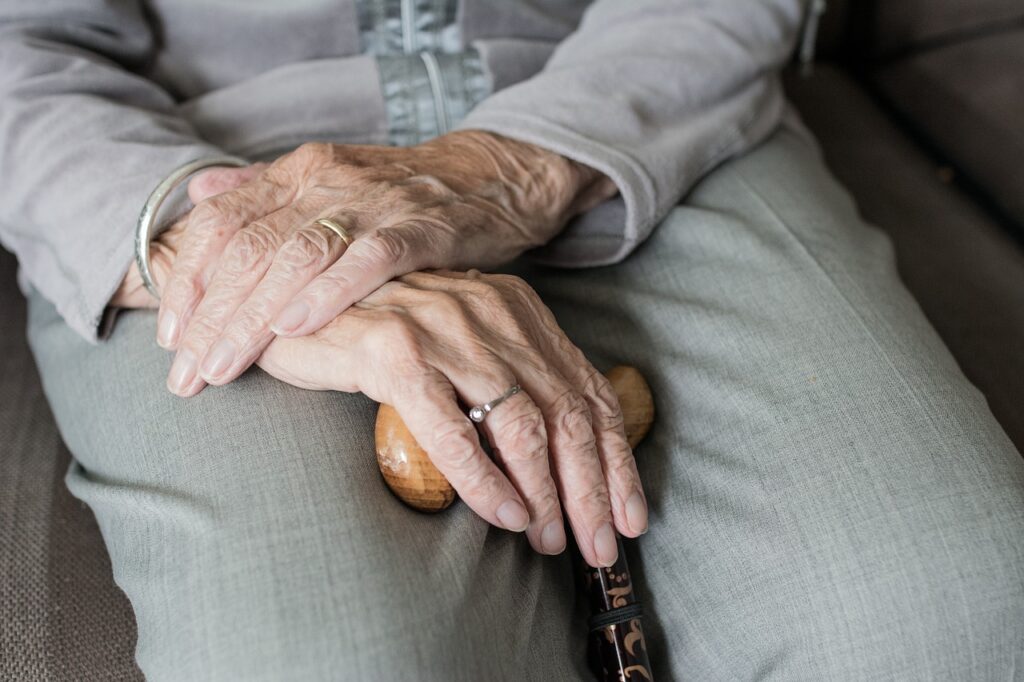 elderly woman's hands holding cane