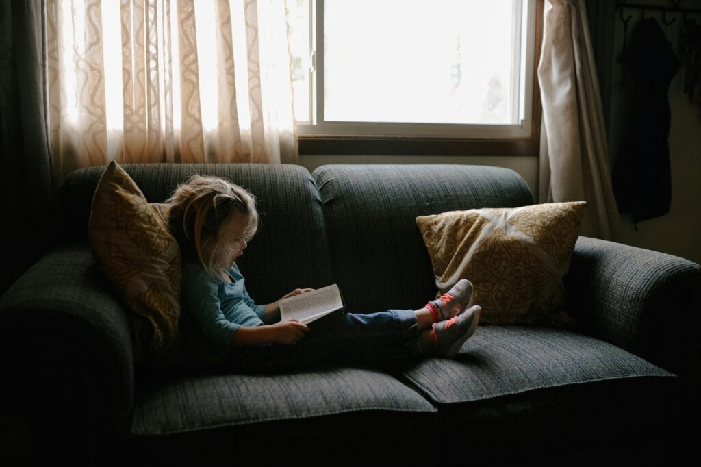 girl on couch reading Bible