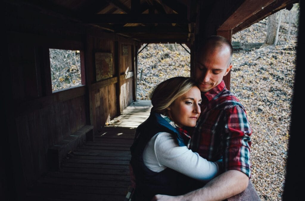 couple hugging in barn woman looks pensive
