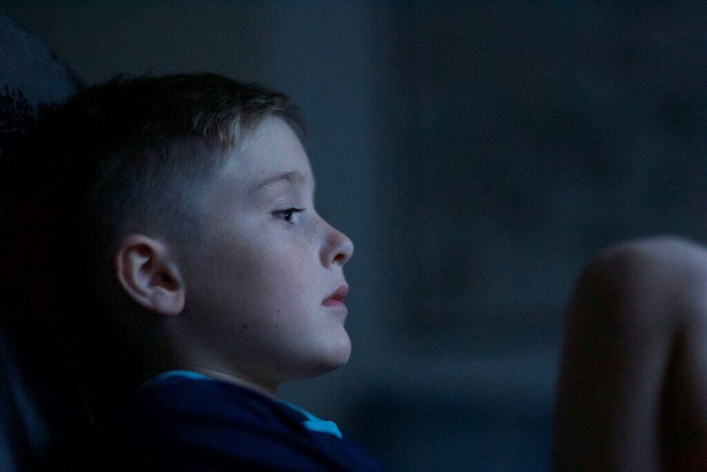 boy sitting in the dark afraid
