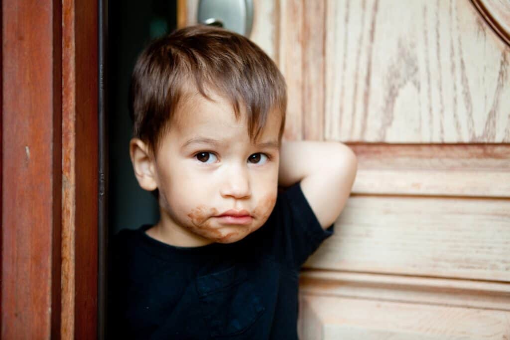 little boy standing by front door