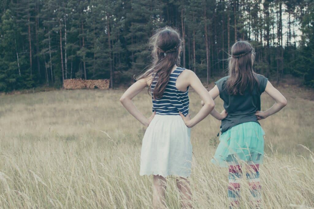 sisters backs turned hands on hips