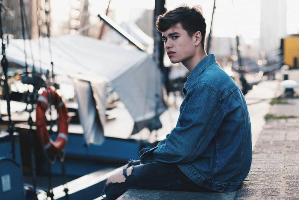 upset boy sitting by dock