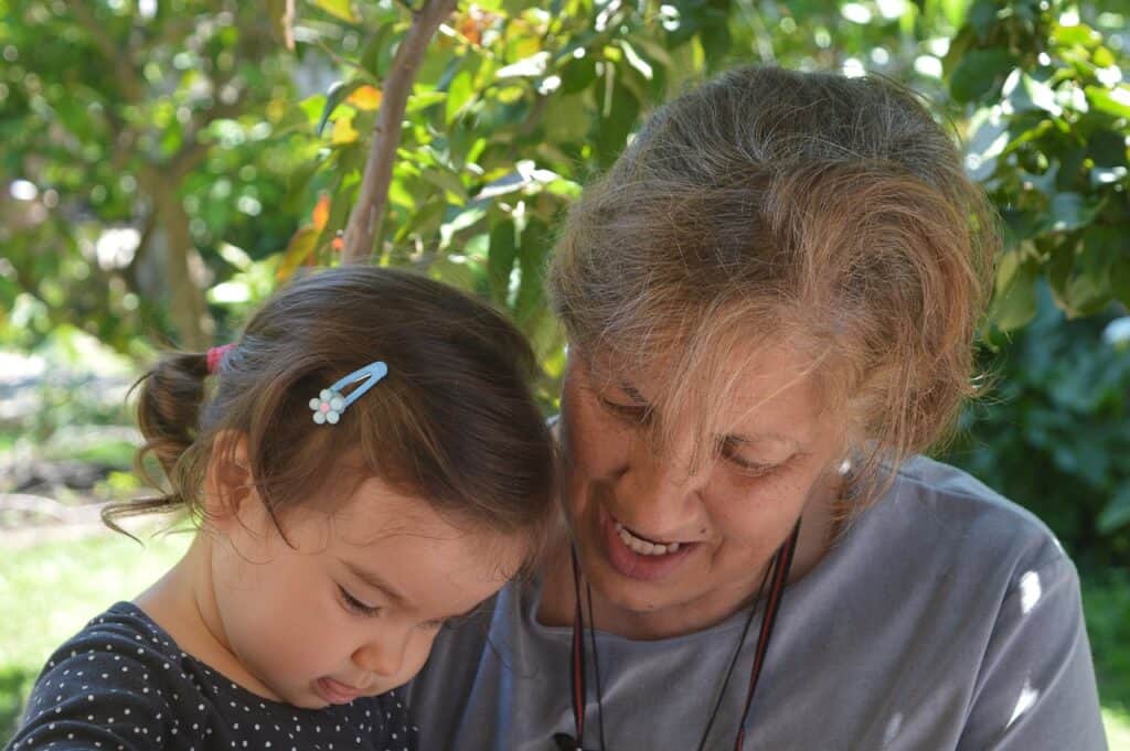 Granddaughter and grandmother looking down at something