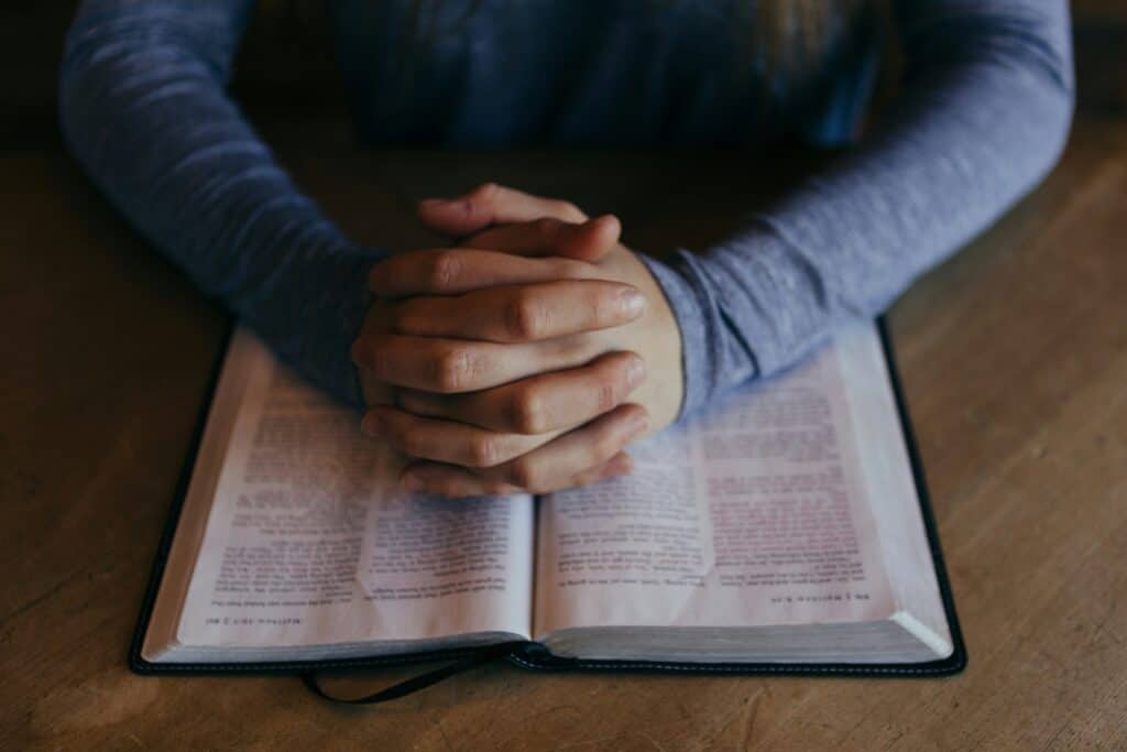 praying hands on Bible