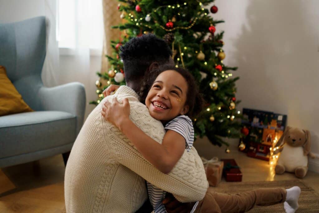 child hugging dad confident and happy christmas tree