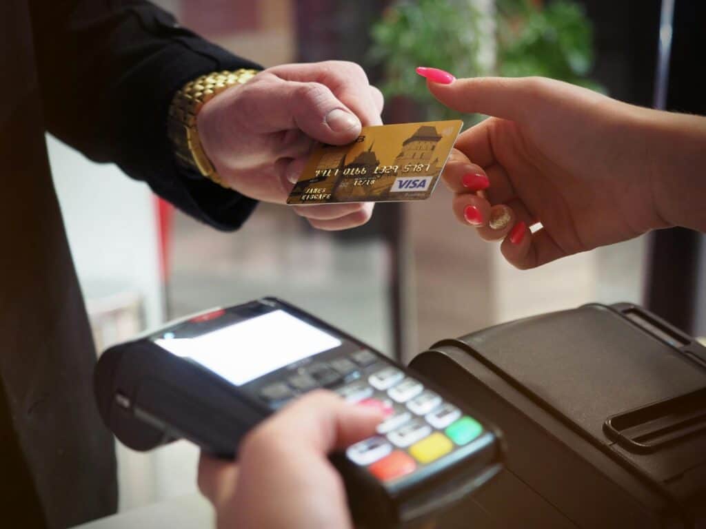 man with gold watch using credit card in store