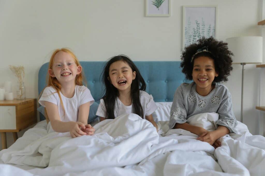 three little girls in bed sleepover