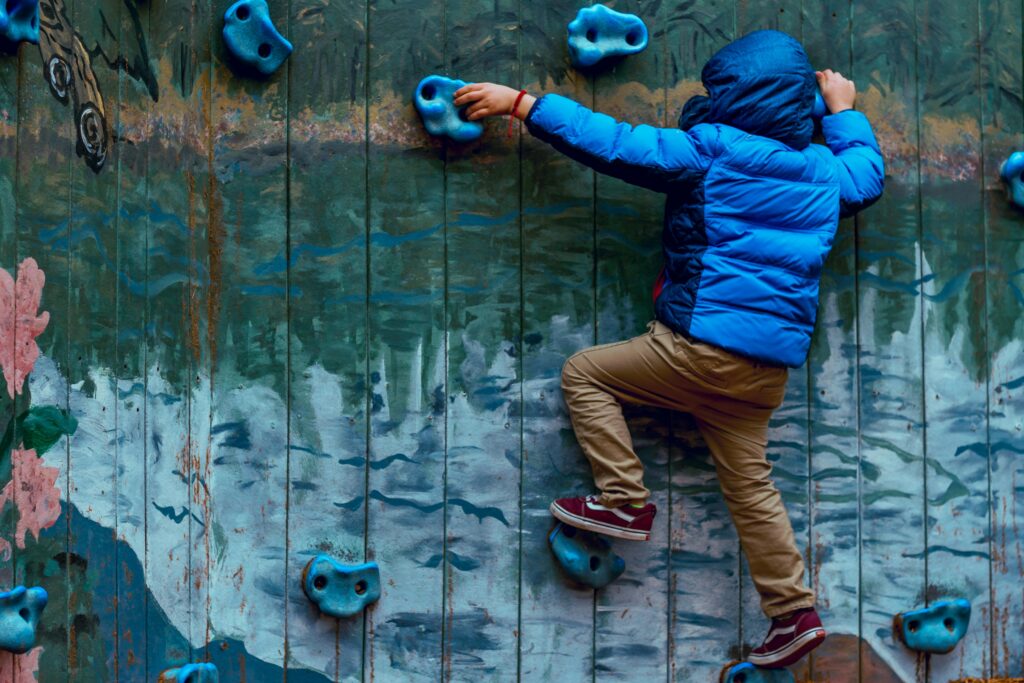 school child on climbing wall