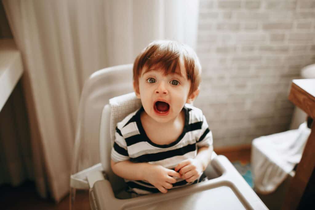 baby in high chair with mouth wide open