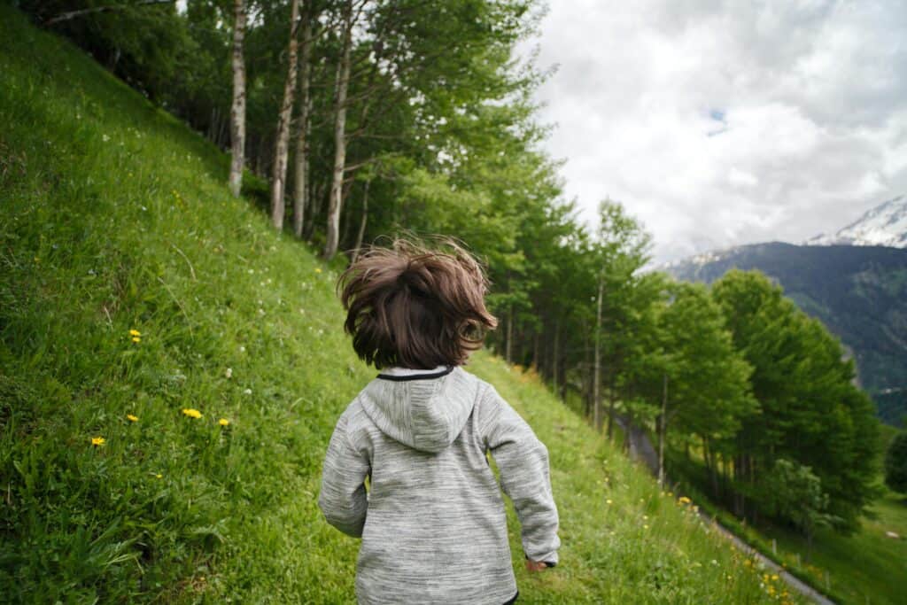 boy running away into mountains forest