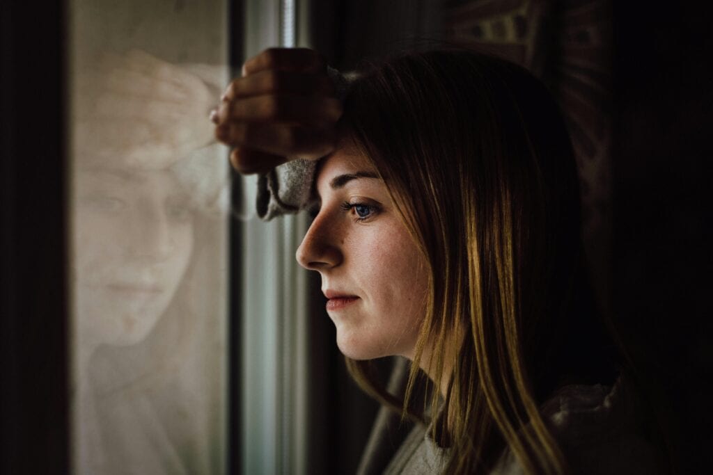 woman looking out the window sad