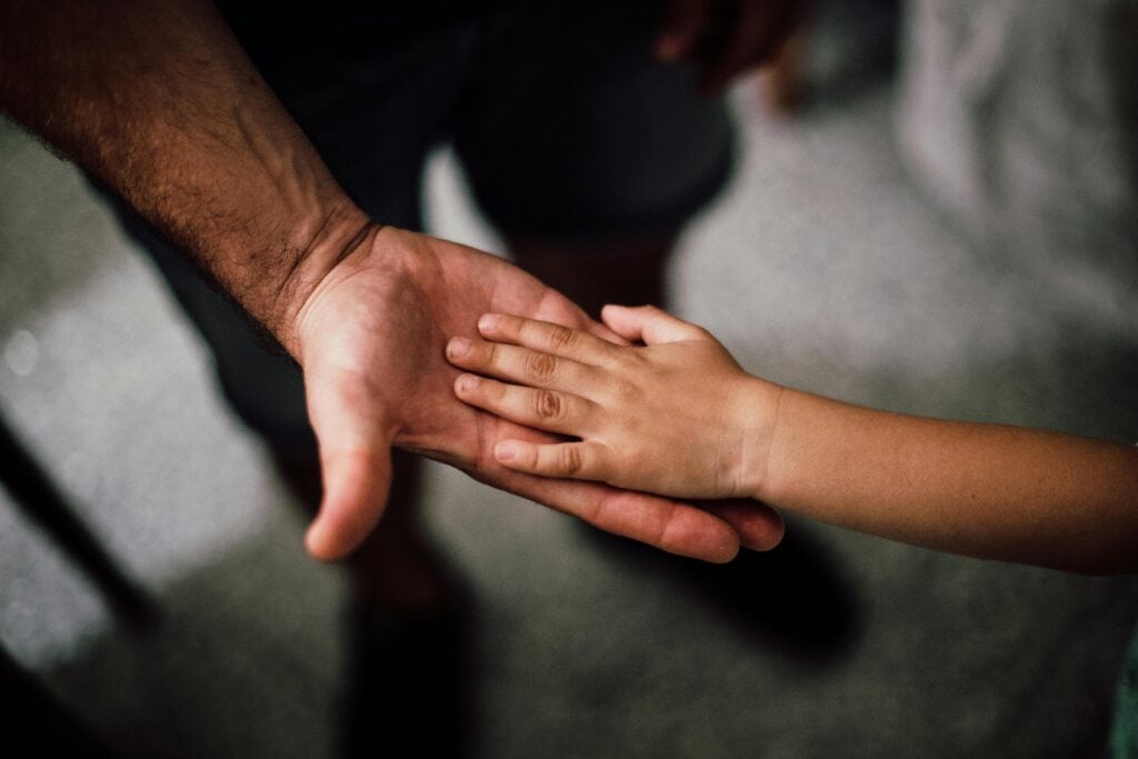 Father and child touching hands