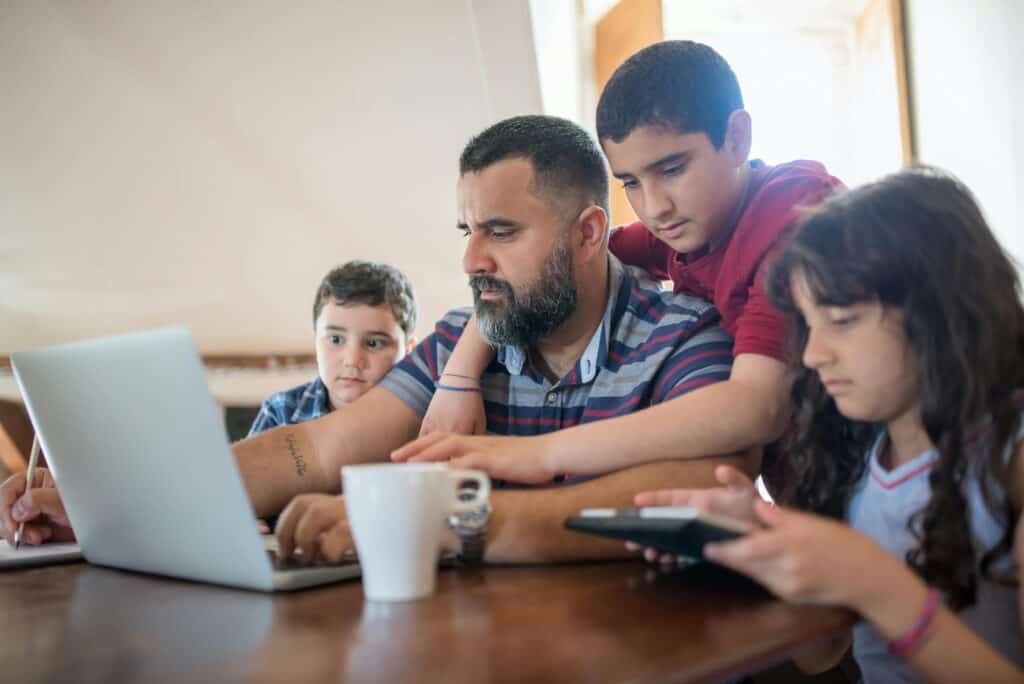 dad on computer kids nearby watching or on other devices