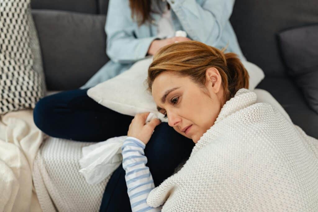 woman head on another woman's lap crying